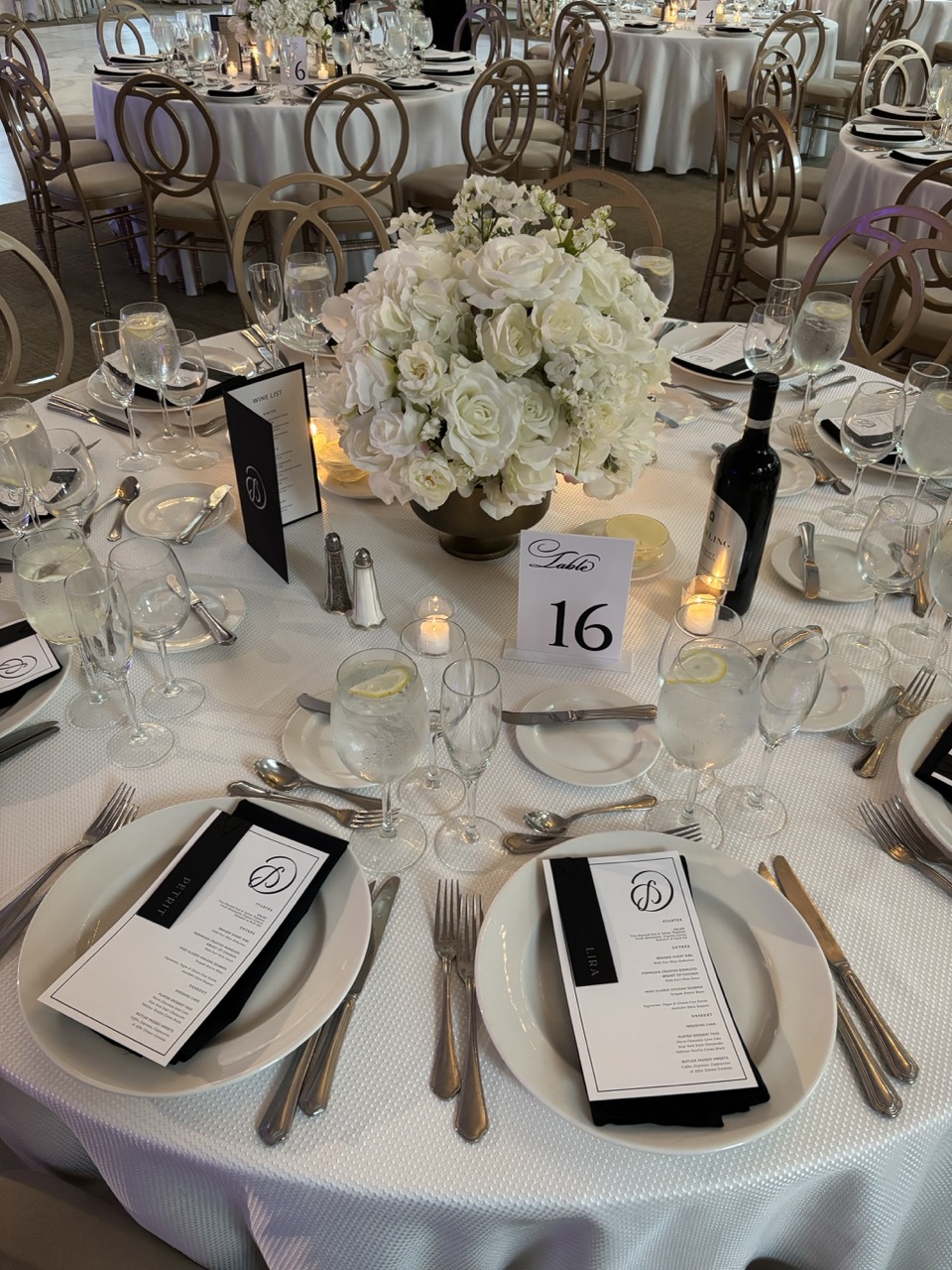 Elegant wedding reception table at Florentine Gardens in River Vale, New Jersey, featuring white floral centerpieces, black-and-white menus, candlelight, fine glassware, and classic place settings ready for guests.
